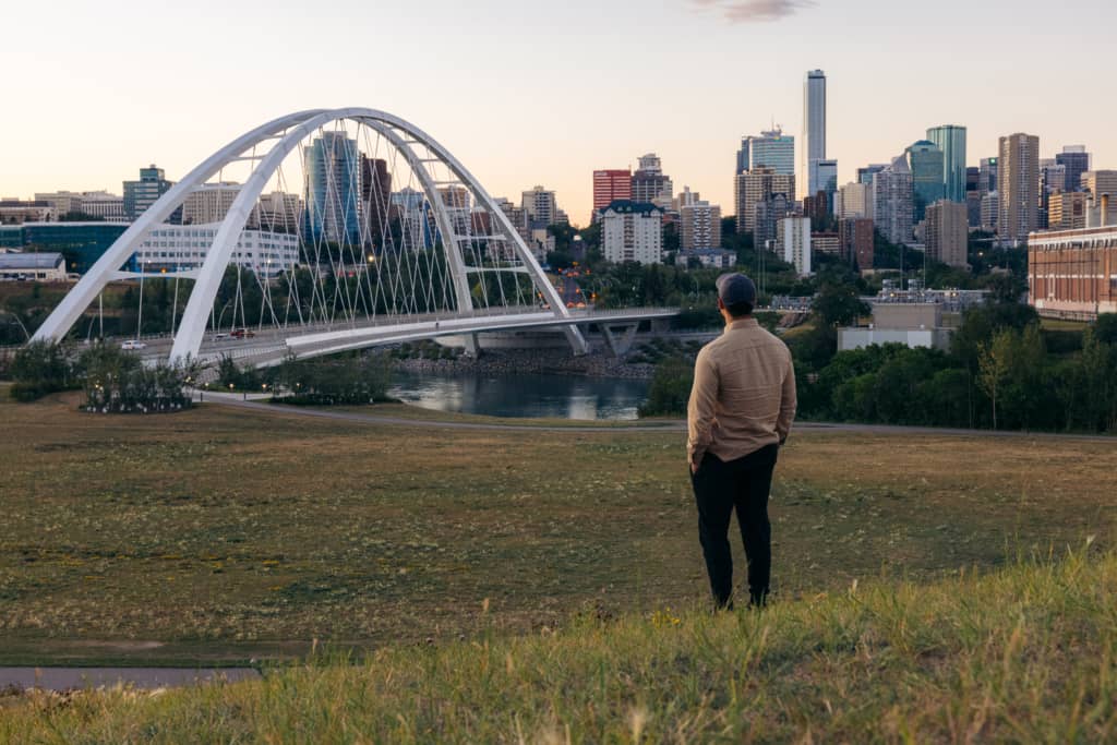 Walterdale Park Man looks at Walterdale Bridge with city skyline in background